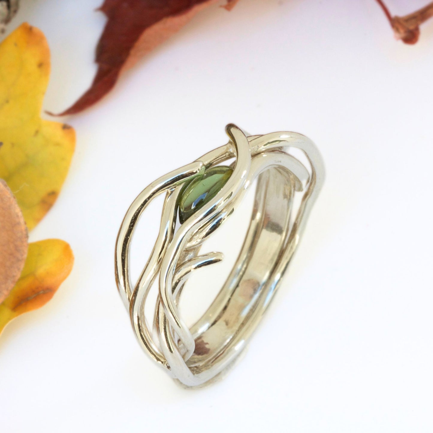 Unique entwined gold infinity ring set with a marquise natural gemstone.