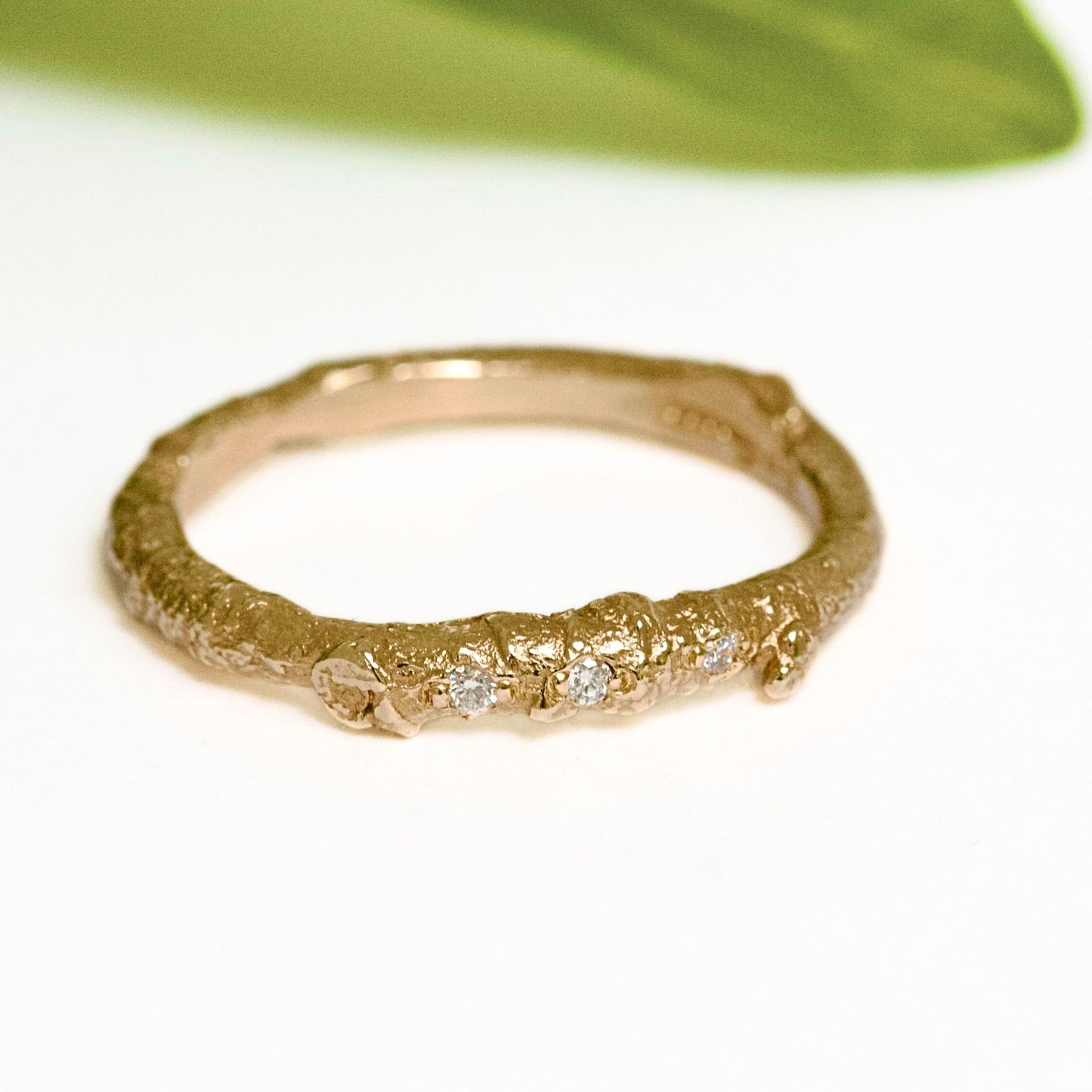 A nature twig wedding ring cast from a real twig in 9ct gold and embedded with three white natural diamonds.