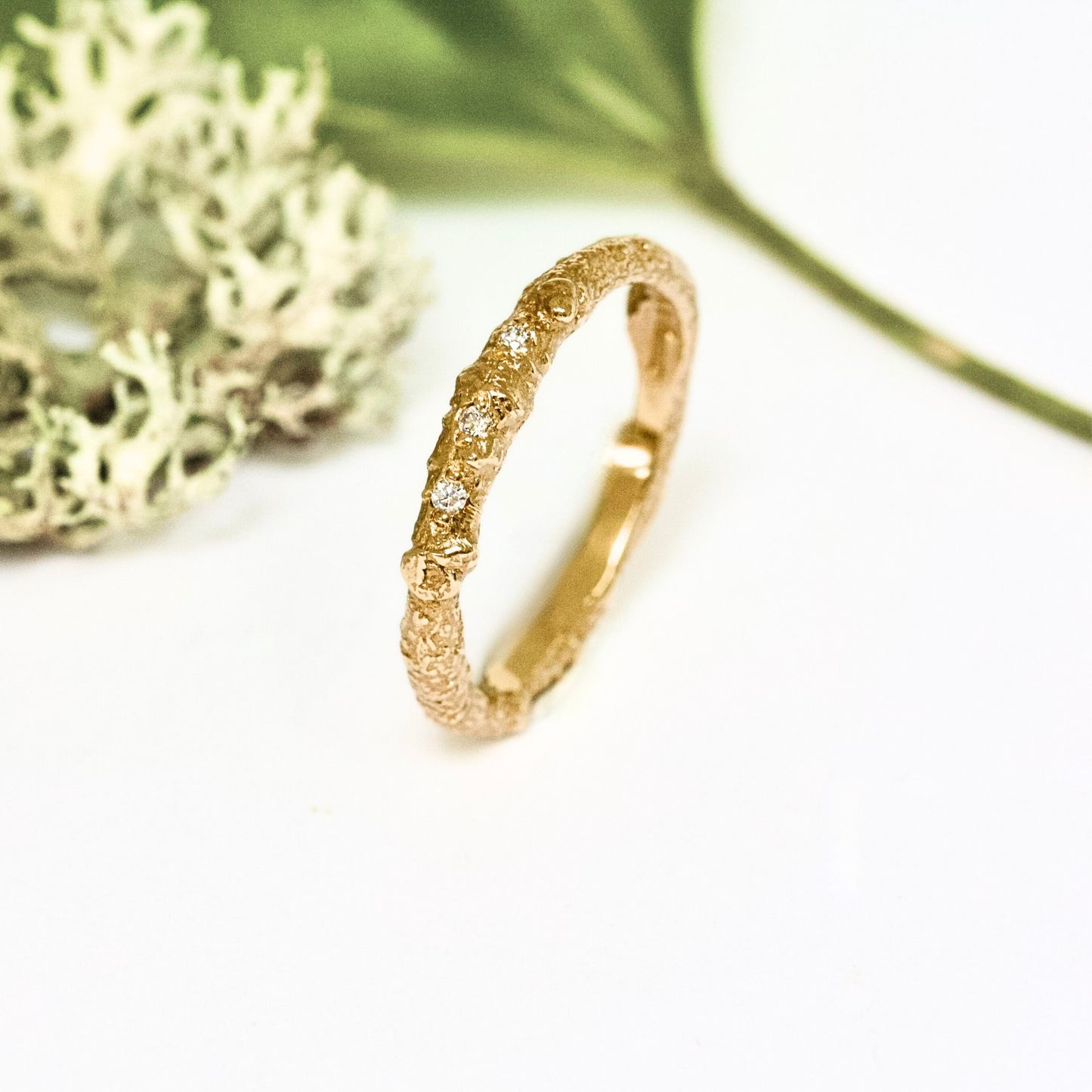 A nature twig wedding ring cast from a real twig in 9ct gold and embedded with three white natural diamonds.