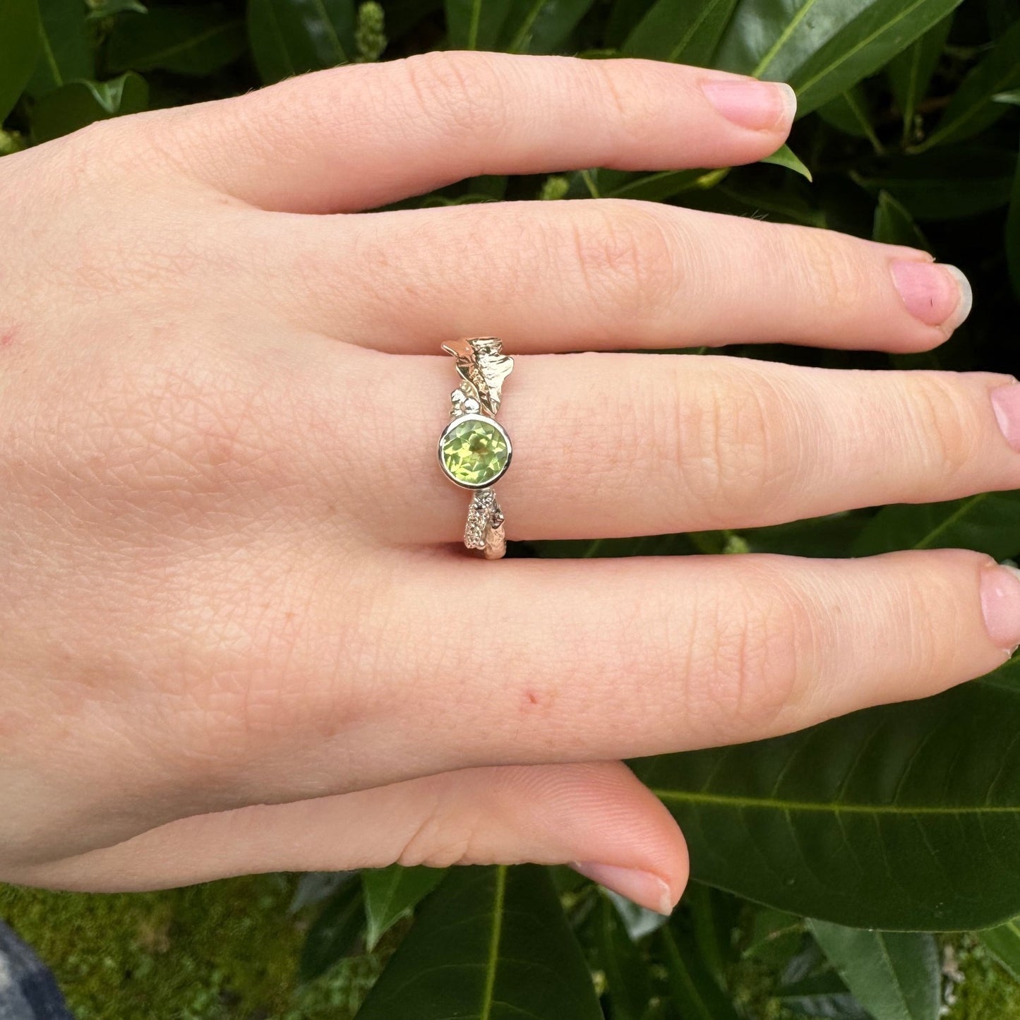 Peridot, August Birthstone, set on a 9ct white gold twig band with a contrasting hand pierced and engraved 9ct rose gold oak leaf. Alternative Nature Inspired Engagement Ring.