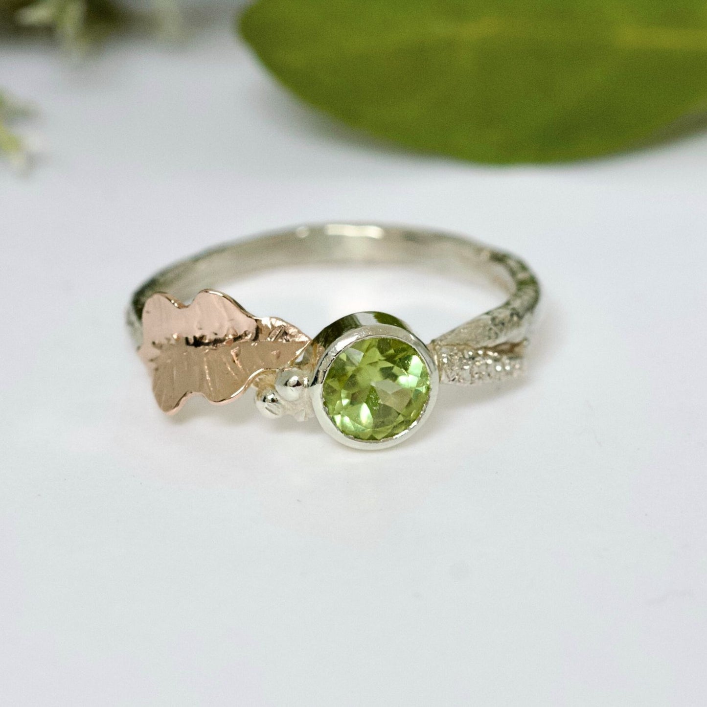white gold twig ring with Peridot and a rose gold oak leaf, alternative organic engagement ring