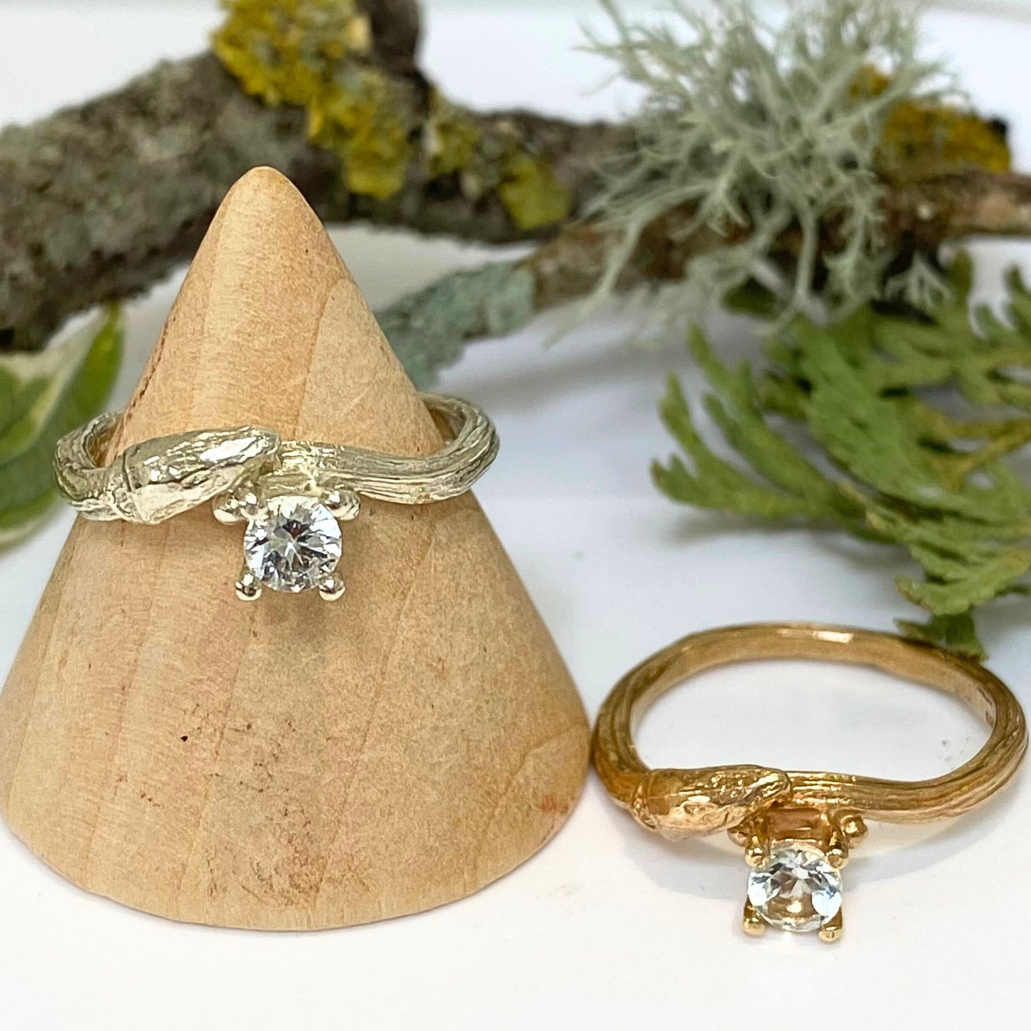 Cast from a real willow twig in 9ct gold, showing the willow bud and bark details, this nature inspired twig ring is set with a brilliant cut natural white sapphire.