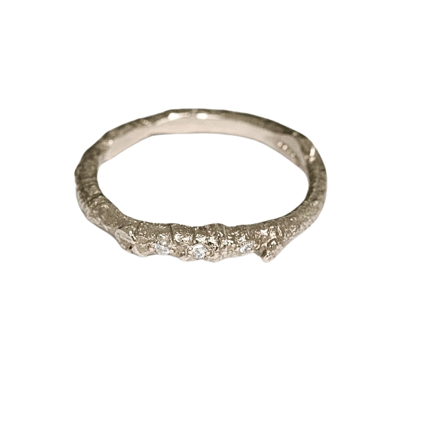 A nature twig wedding ring cast from a real twig in 9ct gold and embedded with three white natural diamonds.