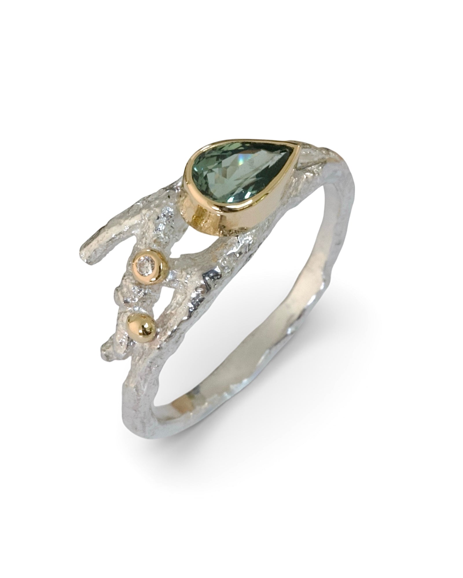 Silver ring with a green gemstone and gold accents on a white background
