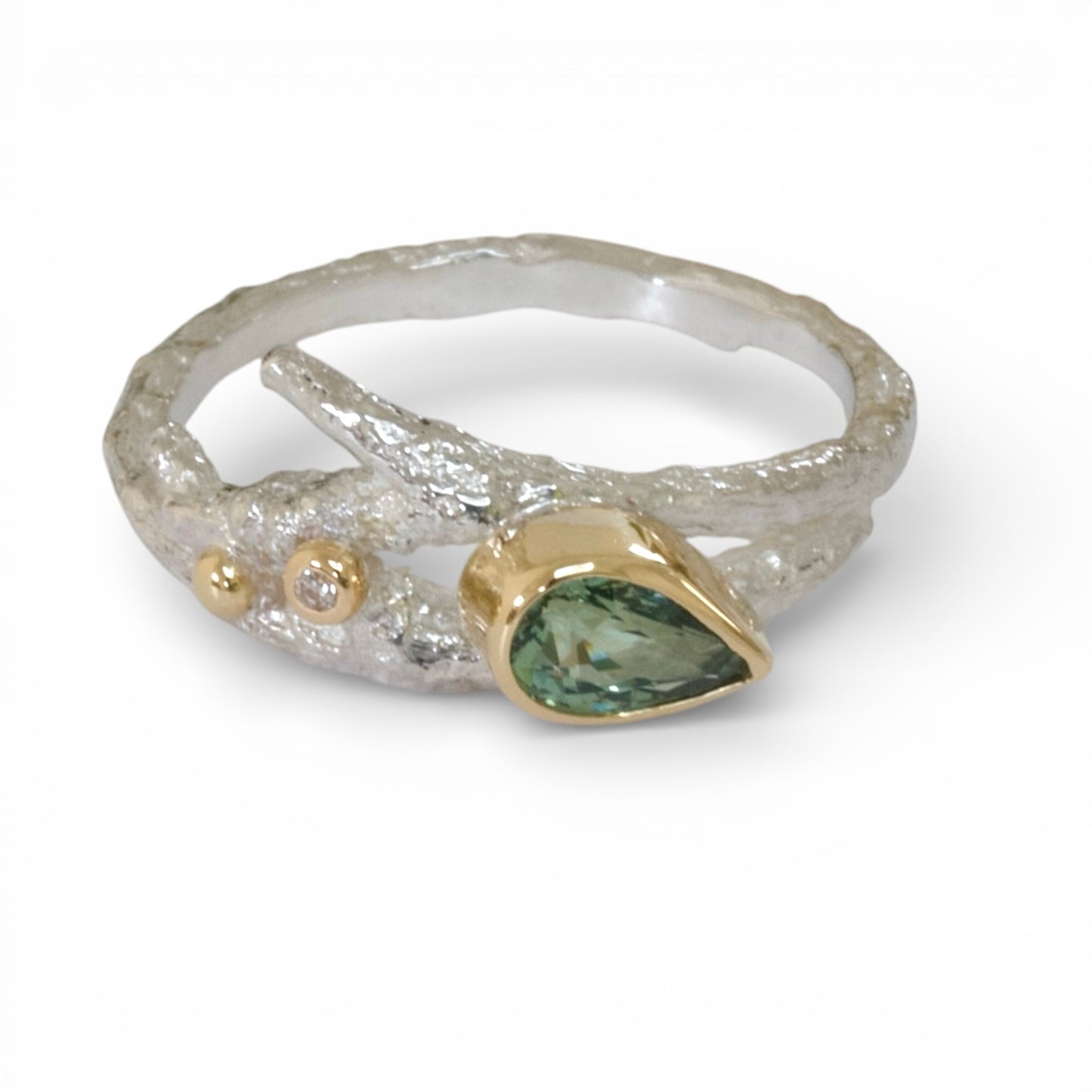 Ring with green gemstone and gold accents on a white background