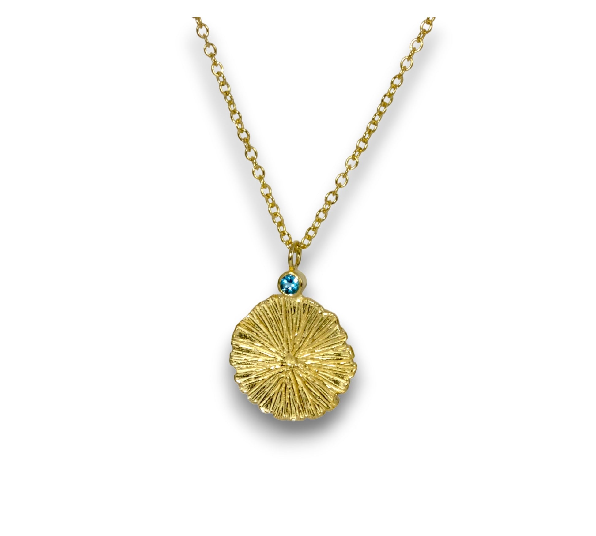 Gold necklace with a textured pendant and a blue topaz gemstone