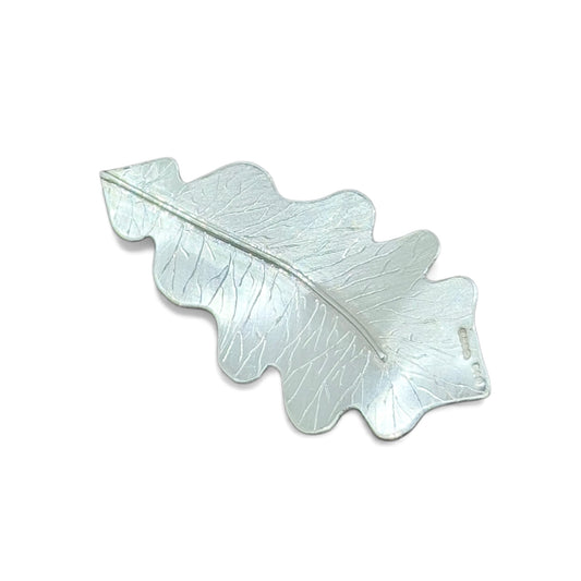 Silver leaf-shaped pendant on a white background