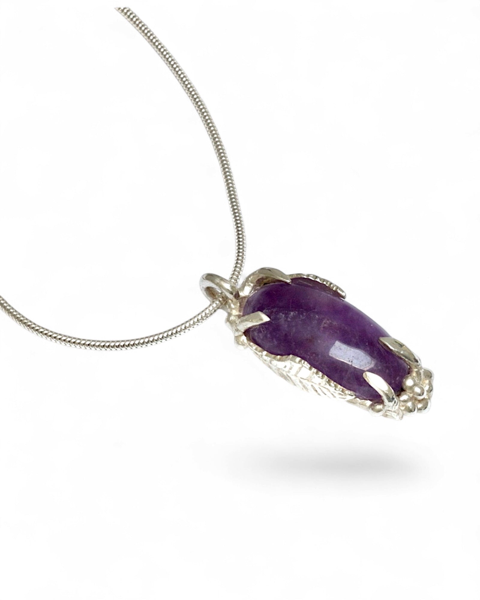 Hand carved sterling silver pendant with long oval cabochon amethyst, nature inspired twig and leaf setting on silver snake chain
