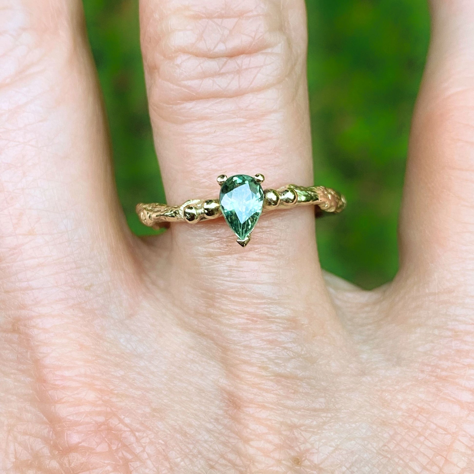 Pear shape green sapphire nature inspired twig engagement ring. Cast from a real twig in 9ct yellow gold and set with a teardrop green sapphire in a claw setting. Also can be ordered in white gold.