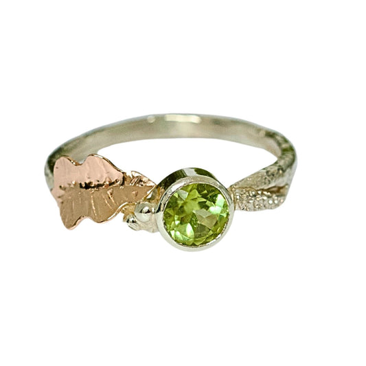 Peridot, August Birthstone, set on a 9ct white gold twig band with a contrasting hand pierced and engraved 9ct rose gold oak leaf. Alternative Nature Inspired Engagement Ring.