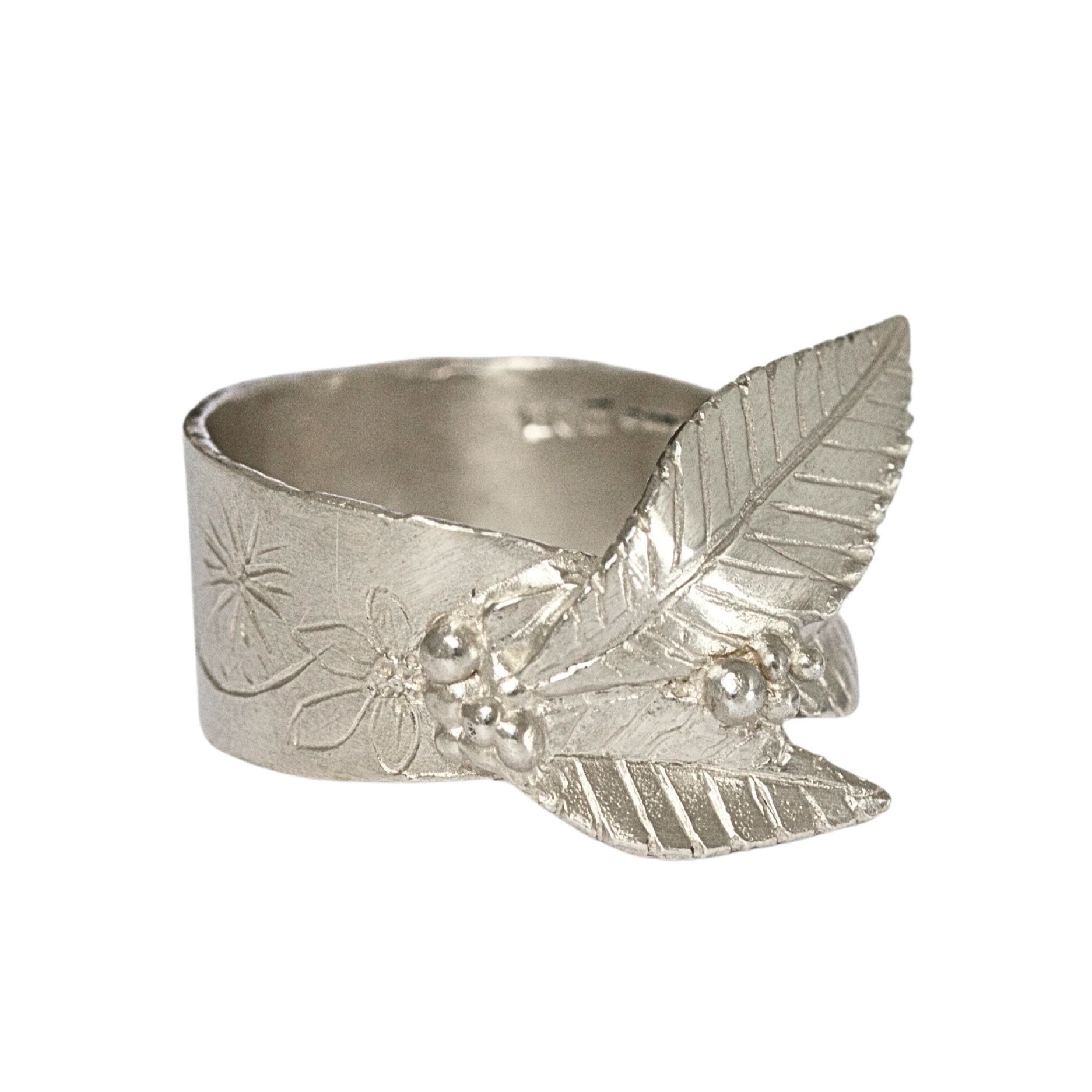 Arts and Crafts style handmade silver nature ring featuring engraved floral design and carved sculptural leaves.