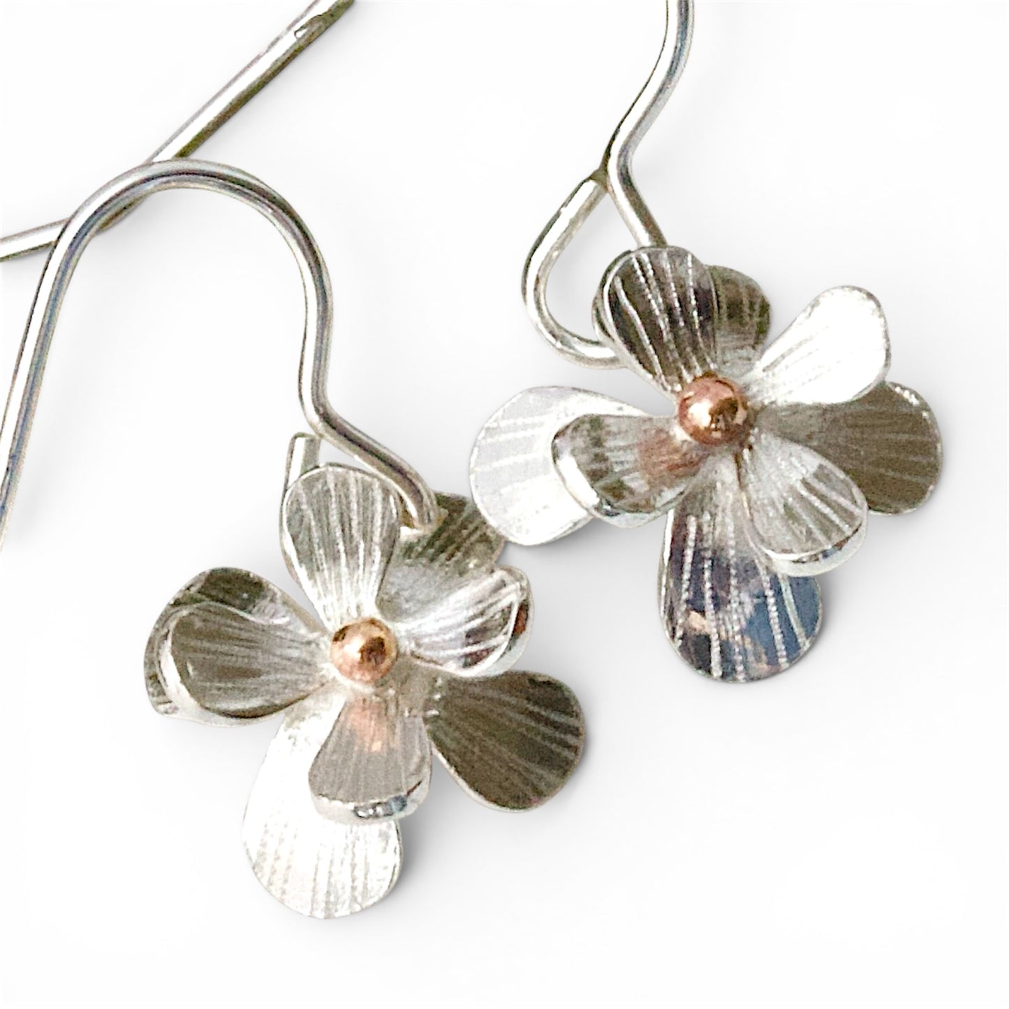 Sculptural small sterling silver flower earrings. Drop Dangle style in sterling silver with a solid rose gold centre. Mixed Metal Flower Earrings.