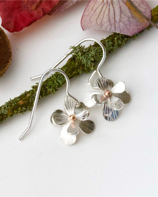 Sculptural small sterling silver flower earrings. Drop Dangle style in sterling silver with a solid rose gold centre. Mixed Metal Flower Earrings.