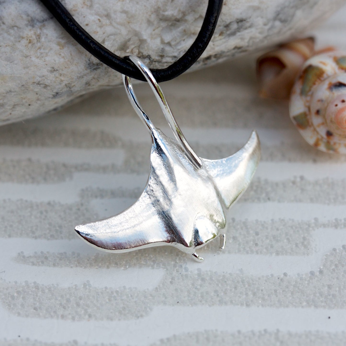 Solid sterling silver manta ray pendant on a faux suede thong necklace.