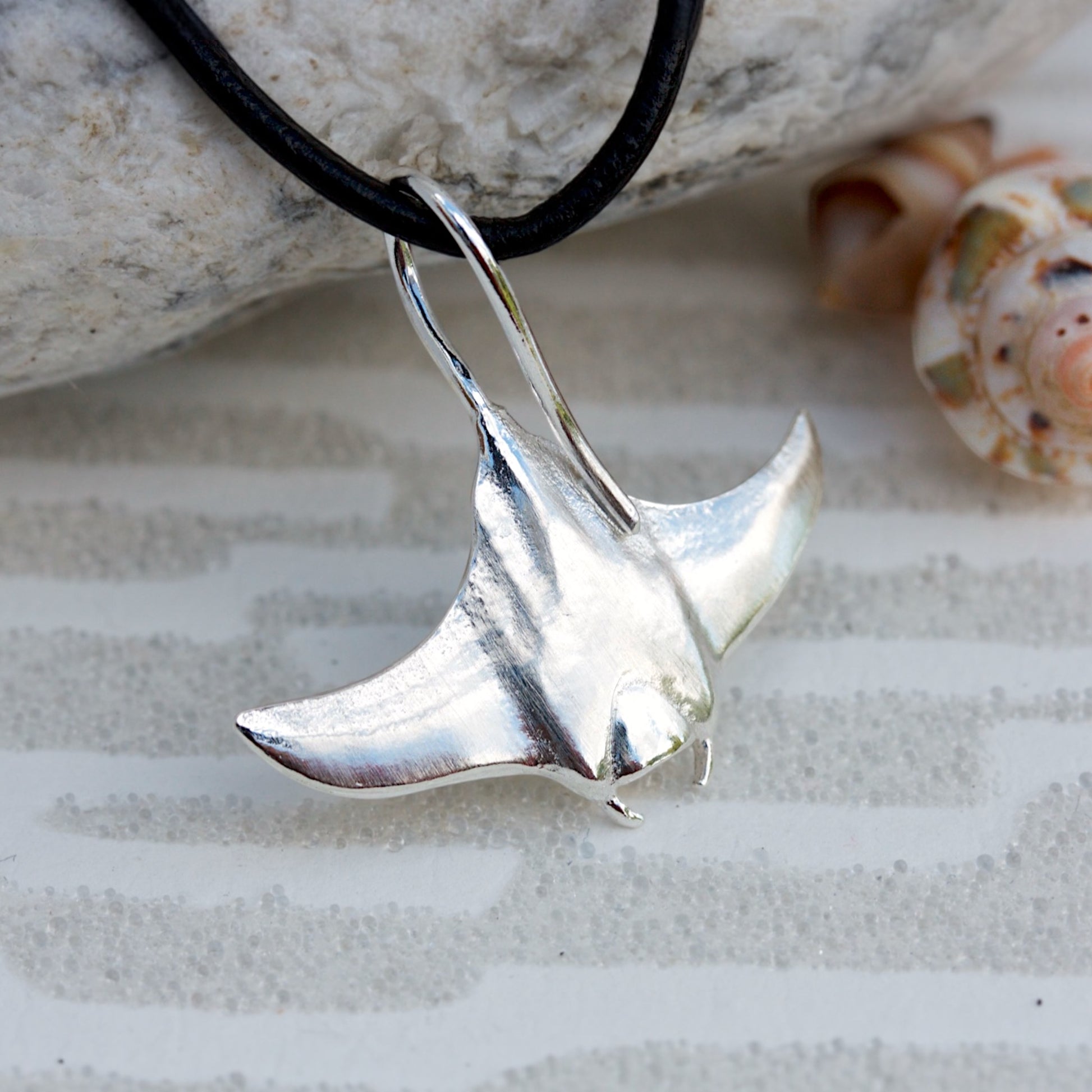 Solid sterling silver manta ray pendant on a faux suede thong necklace.