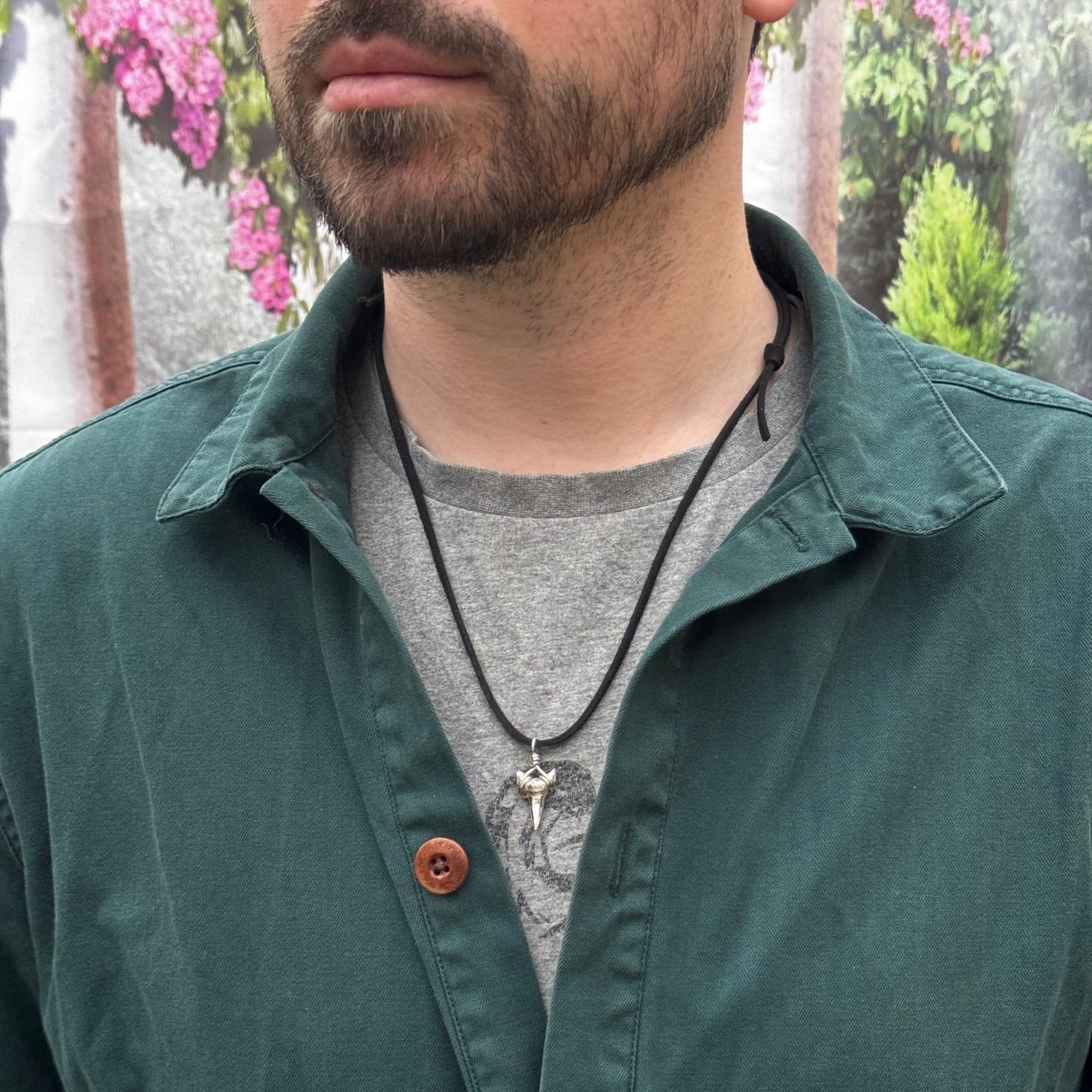 Solid sterling silver shark's tooth pendant on a faux suede thong necklace.