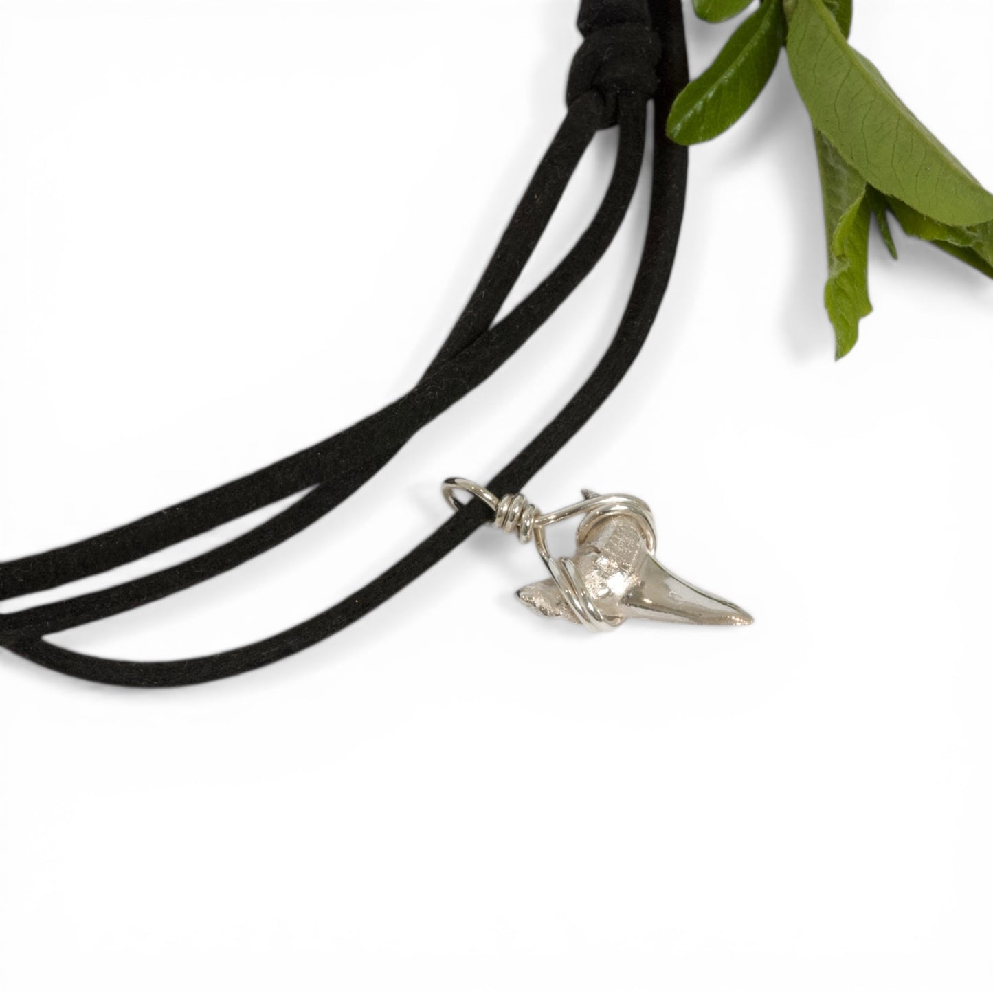 Solid sterling silver shark's tooth pendant on a faux suede thong necklace.