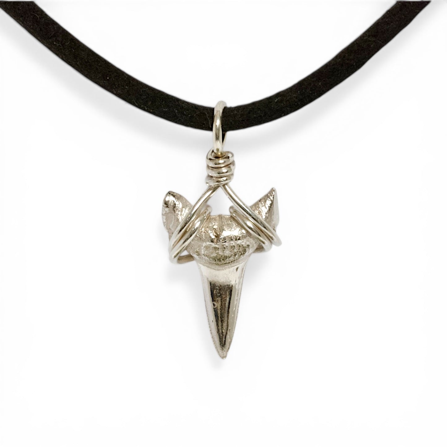 Solid sterling silver shark's tooth pendant on a faux suede thong necklace.