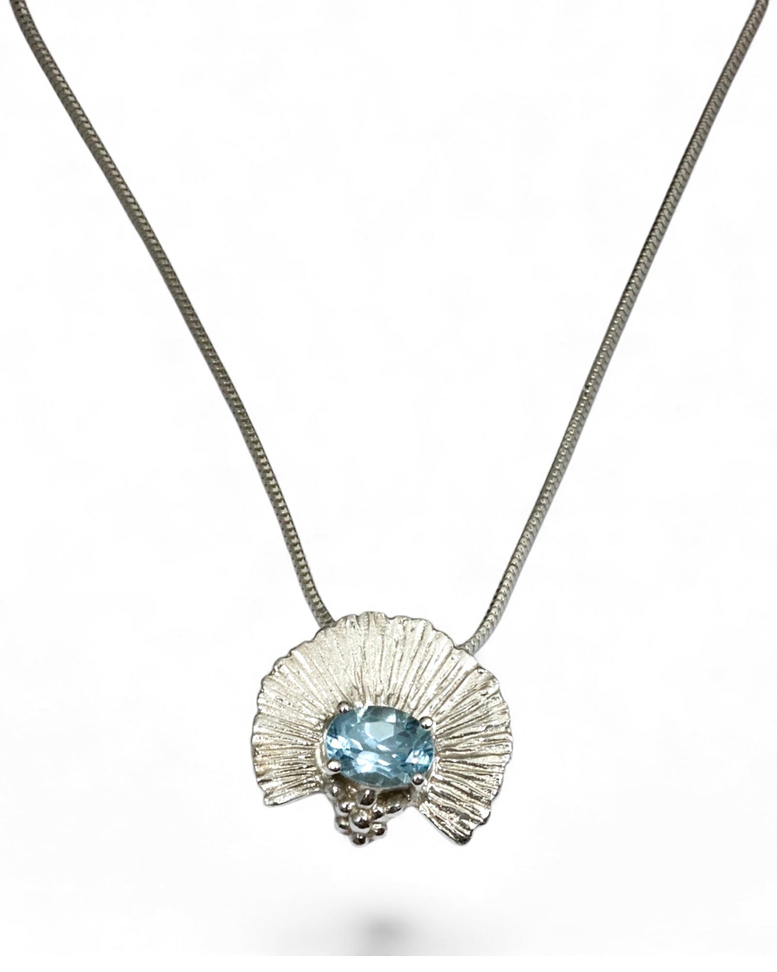 Silver necklace with a pendant featuring a blue gemstone on a white background