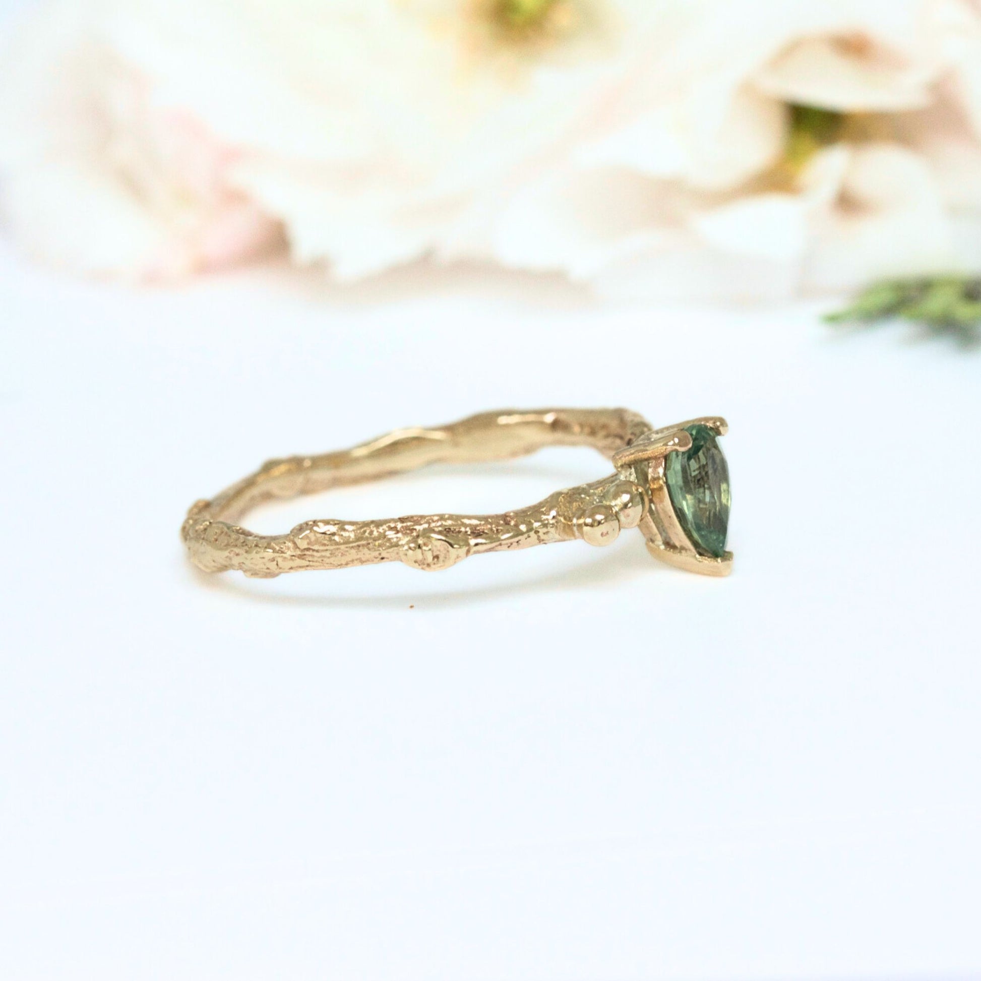 Pear shape green sapphire nature inspired twig engagement ring. Cast from a real twig in 9ct yellow gold and set with a teardrop green sapphire in a claw setting. Also can be ordered in white gold.