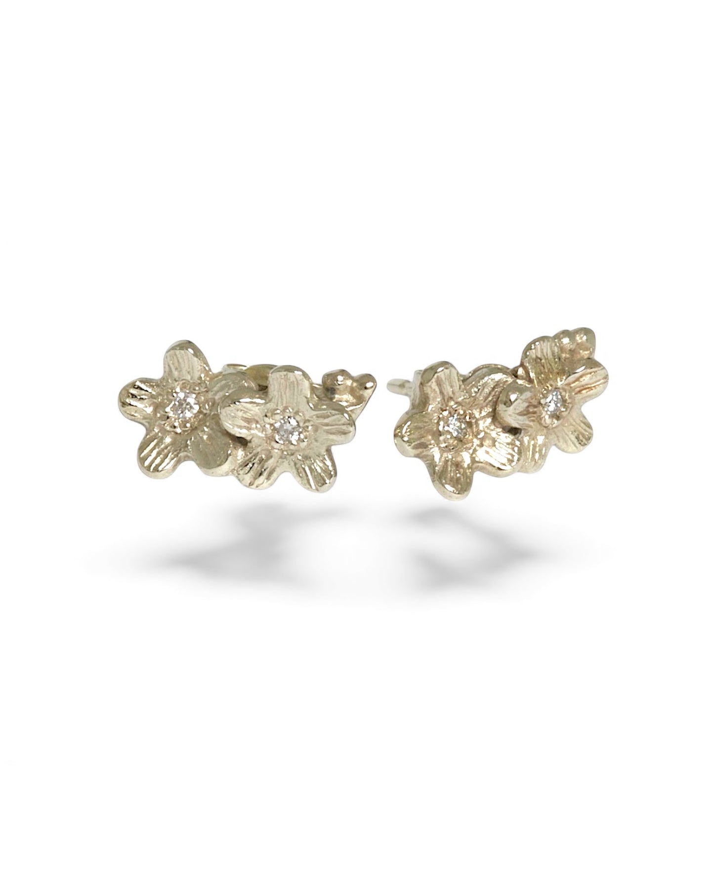 Gold floral tiny diamond earrings on a white background
