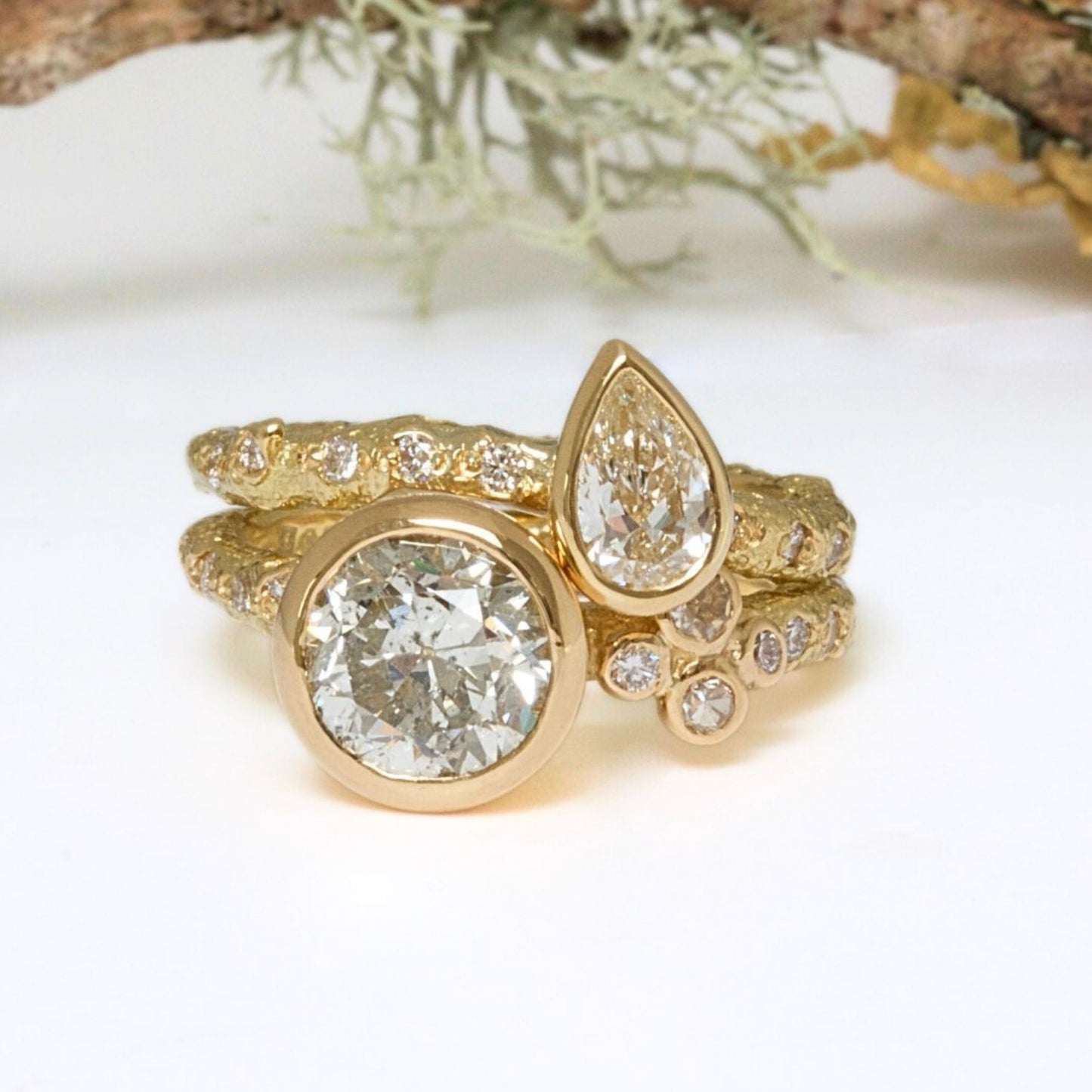 Gold ring with large diamond and smaller teardrop-shaped diamond wedding set.