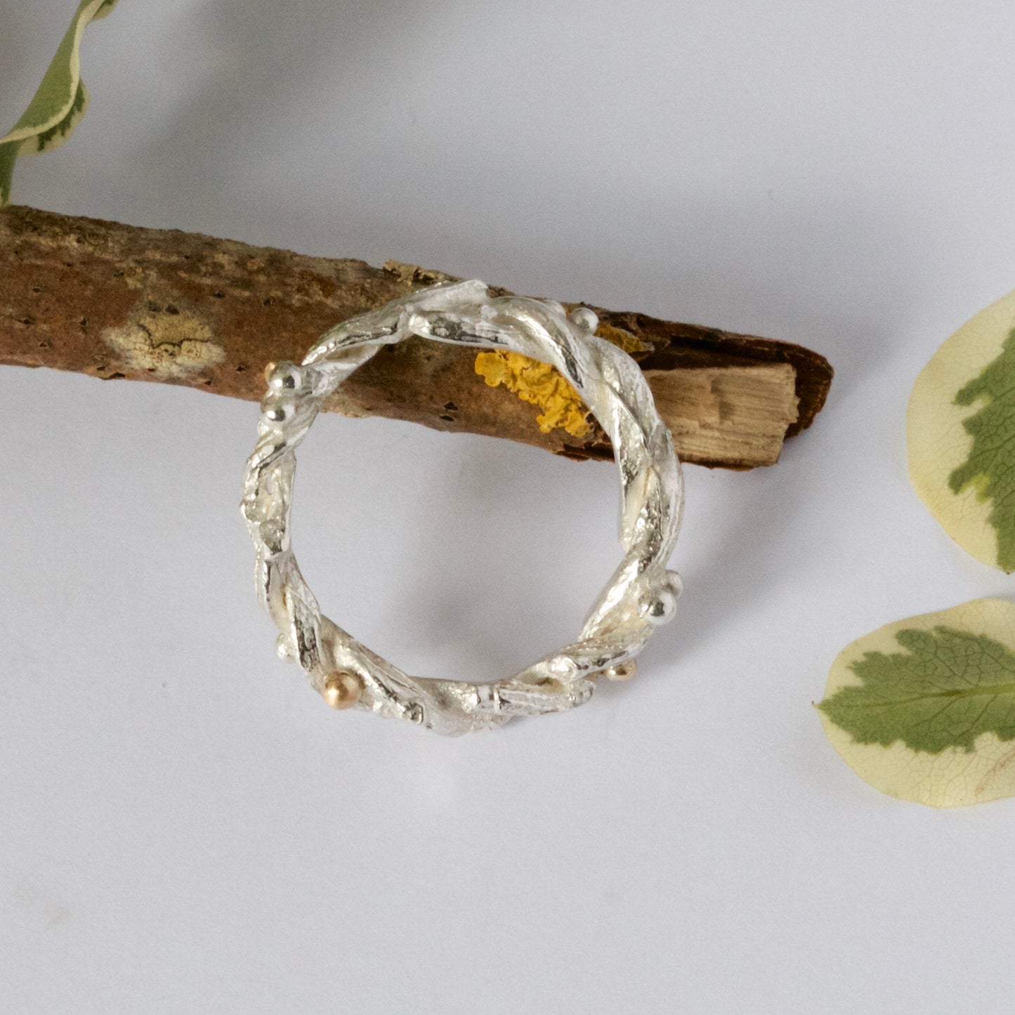 Entwined sterling silver twig ring with silver and 9ct gold berries, handcrafted woodland-inspired design.
