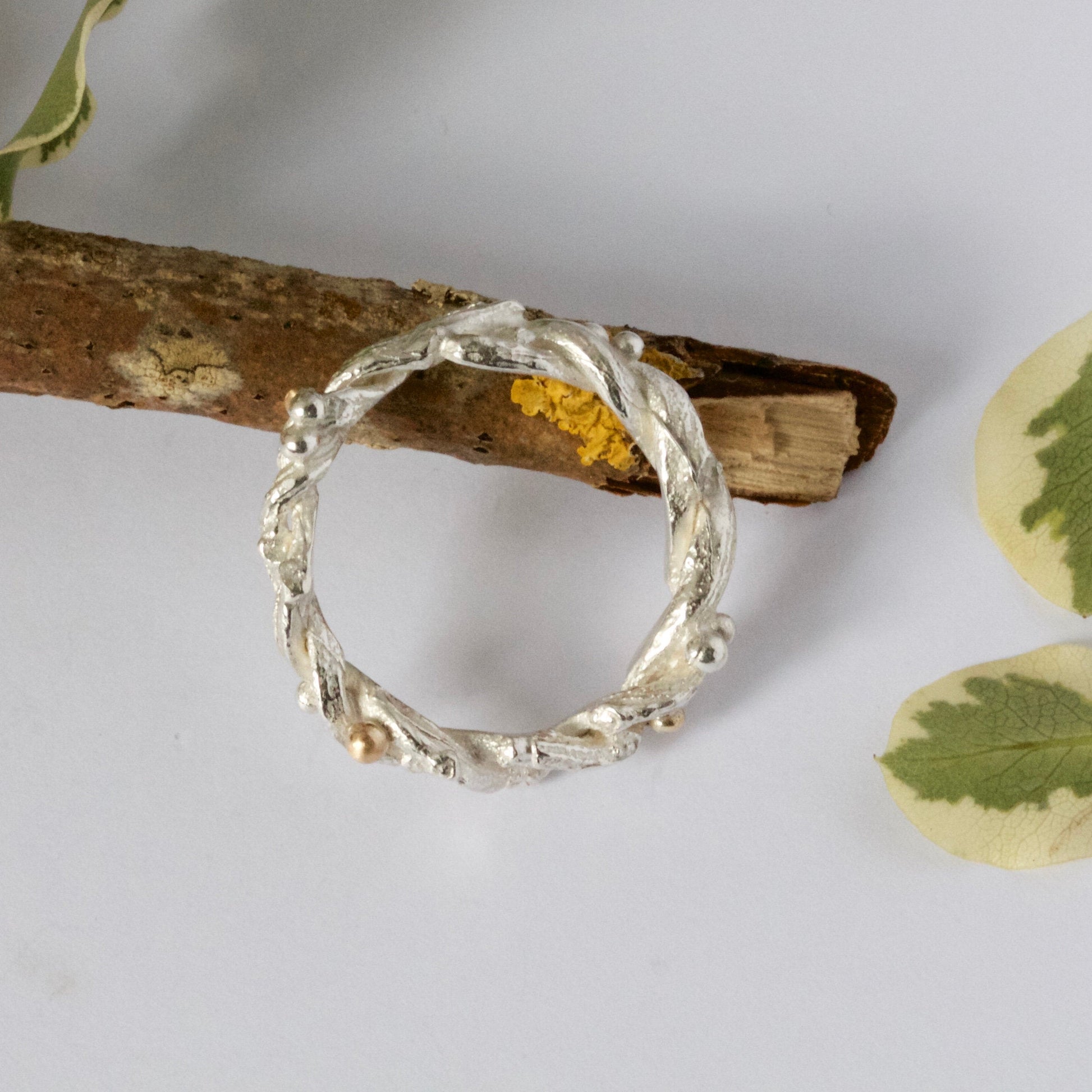 Entwined sterling silver twig ring with silver and 9ct gold berries, handcrafted woodland-inspired design.
