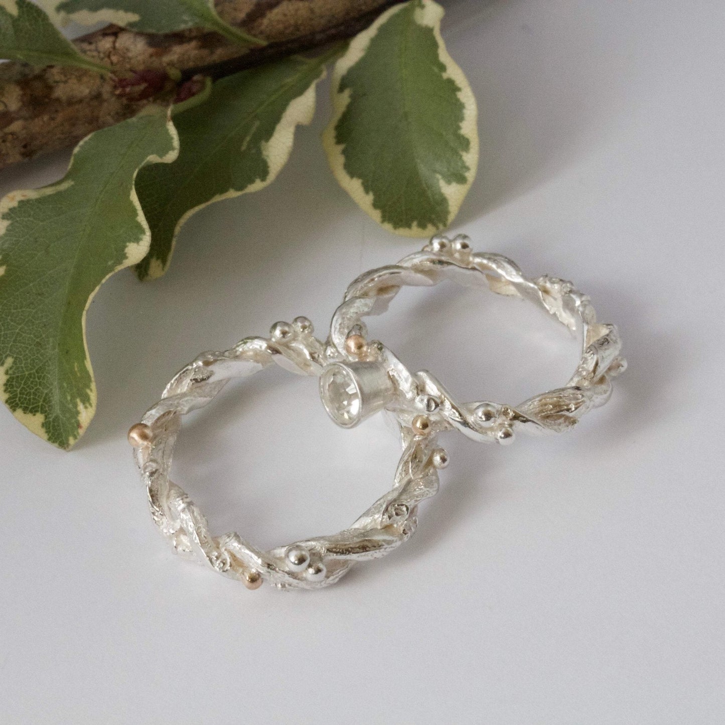 Entwined sterling silver twig ring with silver and 9ct gold berries, handcrafted woodland-inspired design.
